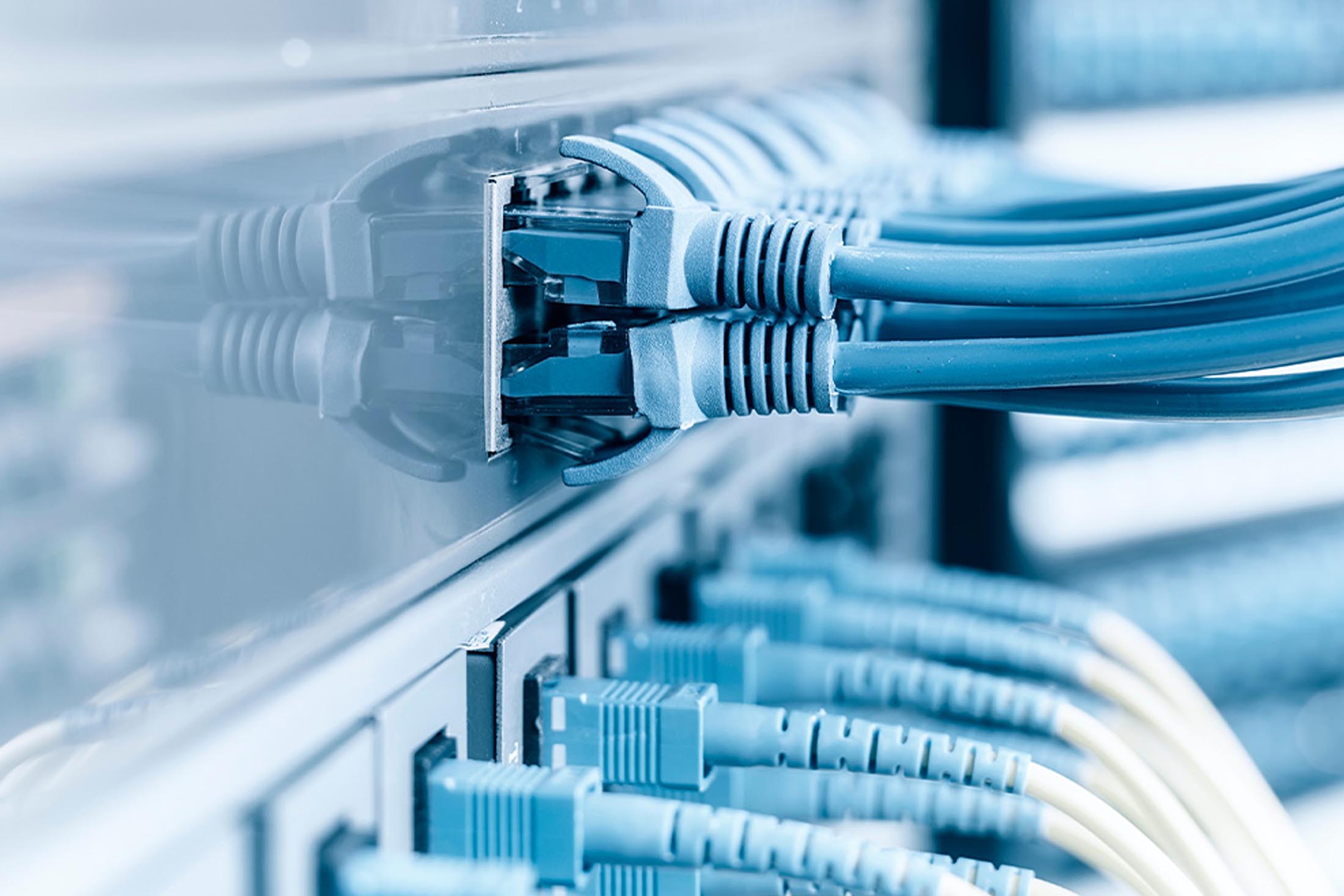 Technician plugging patch cable in a rack mounted server cabling