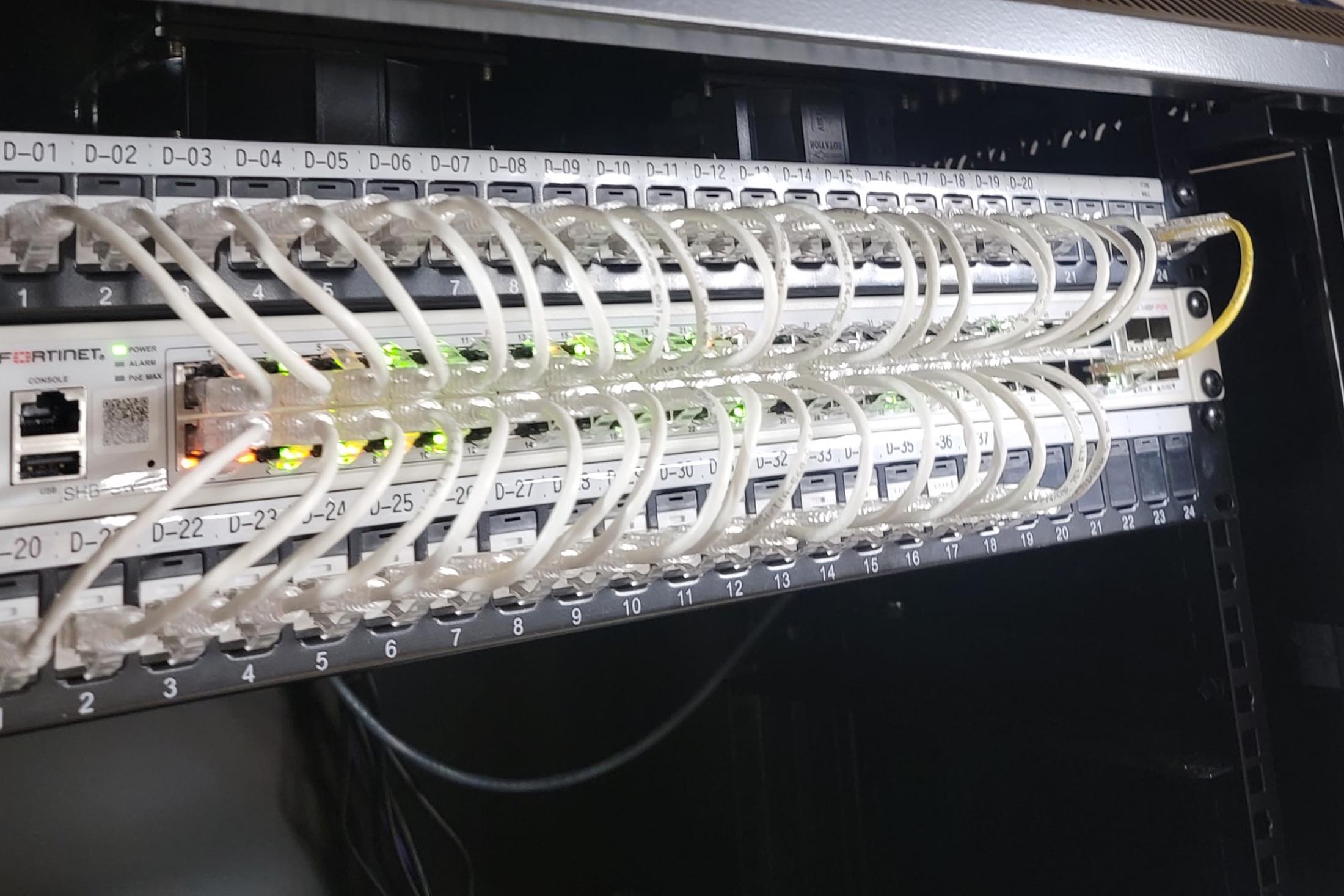 Technician plugging patch cable in a rack mounted server cabling